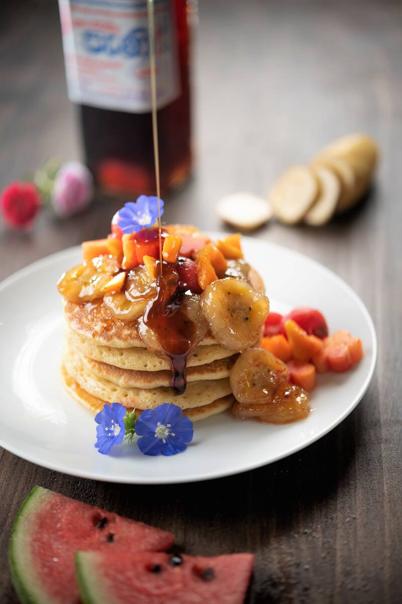 A pancake stack with berries and banana served at Arana