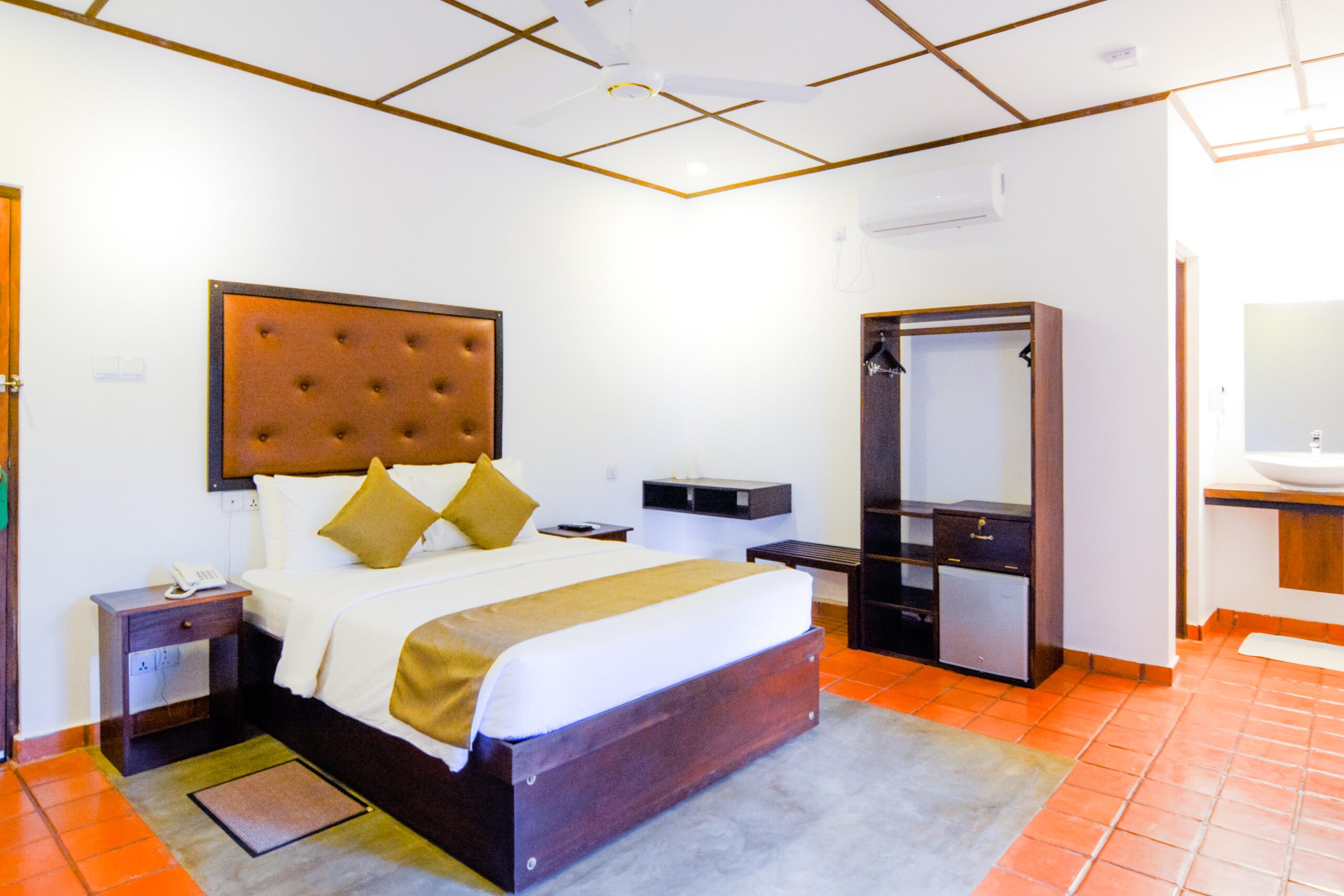 Interior of a Deluxe Room at Arana, with soft linens and a few garden flowers